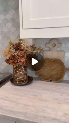 a vase filled with flowers sitting on top of a counter