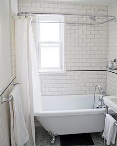 a bathroom with a white tub sitting next to a window