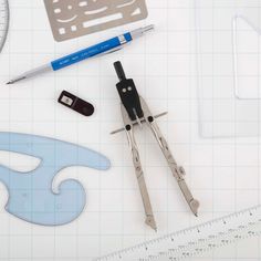 scissors, rulers, and other tools are laid out on a sheet of paper