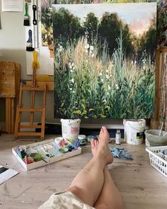 a person laying on the floor with their feet up in front of an easel