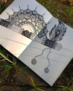 two notebooks sitting in the grass with designs on them