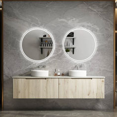 two round mirrors are above the double sinks in this modern bathroom with marble walls and flooring