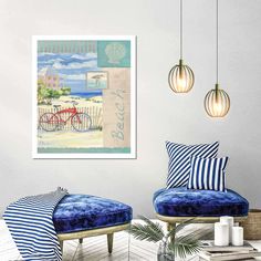 a living room with two blue chairs and a painting on the wall above them that says beach