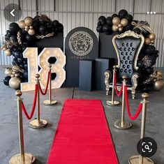 a red carpet is on the ground next to some chairs and poles with rope barriers around them