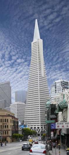 a black and white photo of a very tall building in the middle of a city