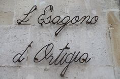 a sign that reads i, sagono d'artigio on the side of a building