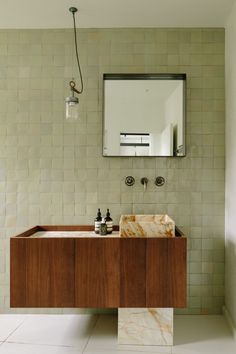 a bathroom with a sink, mirror and soap dispenser on the wall