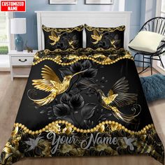 a bed covered in black and gold comforter with two birds on the front, one flying