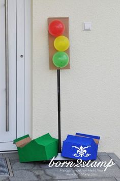 a traffic light sitting on the side of a building next to some boxes and balloons