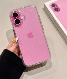 a pink iphone case sitting on top of a table next to a box with an apple logo