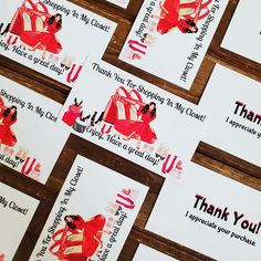 several thank you cards with red and white designs on them are arranged in rows against a wooden background