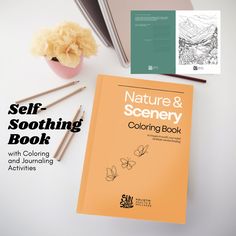 the nature and scenery coloring book is next to two pencils, a potted plant and