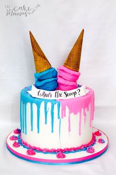 two ice cream cones on top of a cake with blue and pink icing dripping down the sides