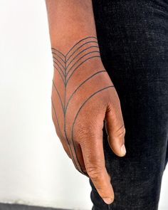 a person with a tattoo on their arm holding onto his hand and pointing to the side