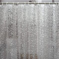 a shower curtain with white and silver dots on it