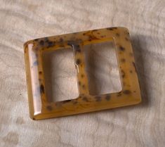 two light switch plates sitting on top of a wooden table