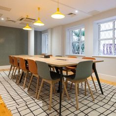 a dining room table with six chairs and a rug on the floor in front of it