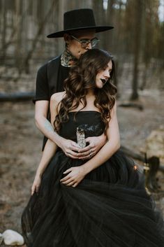 a man and woman dressed in black are holding each other