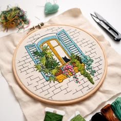 an embroidery project with scissors and thread on the table