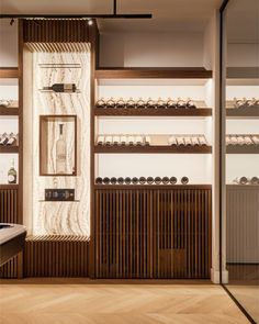 an empty store with wooden shelves filled with bottles and glasses on the wall next to each other