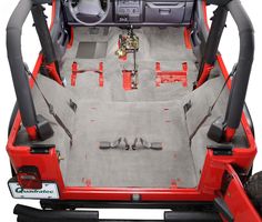 the interior of a red jeep with its doors open