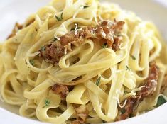 a white bowl filled with pasta and meat