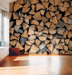 a large pile of wood sitting on top of a wooden floor next to a window