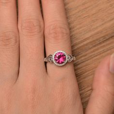 It is a pretty lab ruby ring, the round cut ruby is about 7mm*7mm, weight about 1.66 carats. The basic metal is sterling silver and plated with rhodium. To change the metal to a solid gold (white/rose) or platinum is also available, please ask for a quotation if you want. You can also go to my shop Home for more elegant rings: https://www.etsy.com/shop/godjewelry?ref=hdr_shop_menu Ruby is the birthstone of July, it will be a great gift for your lover! More ruby rings: https://www.etsy.com/shop/g Ruby Ring Engagement, Rubin Ring, Round Cut Ring, Red Gemstone Ring, Ruby Engagement Ring, Red Gemstones, Halo Engagement Rings, July Birthstone, Elegant Ring