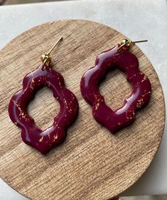 a pair of red earrings sitting on top of a wooden table