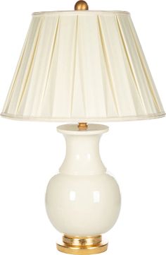 a white table lamp with a gold base