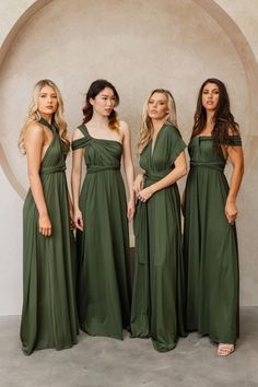 the bridesmaids are wearing green dresses and standing in front of a circular wall