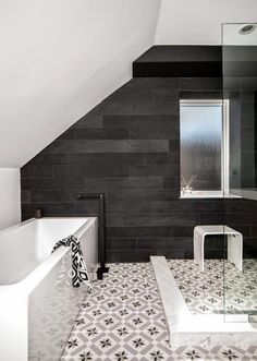 a white bath tub sitting under a window in a bathroom