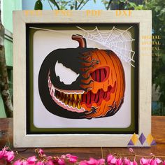 a paper cut out of a jack - o'- lantern is displayed in a frame