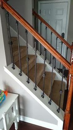 there is a small white bench next to the stairs in this house with wood handrails