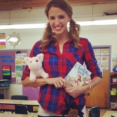 a woman is holding a book and a stuffed animal in her hands while smiling at the camera