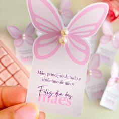 a person holding up a pink card with a butterfly on it and the words filiz de los pires written in spanish