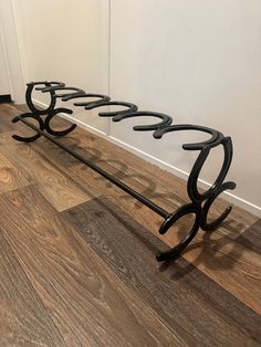 a black metal rack with five hooks on it