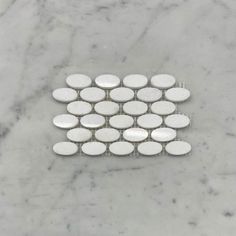 white marble mosaic tile with circles in the middle on a gray marble countertop, viewed from above