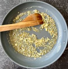 a pan filled with food and a wooden spoon