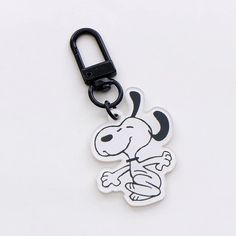 a black and white keychain with a cartoon dog on it's side