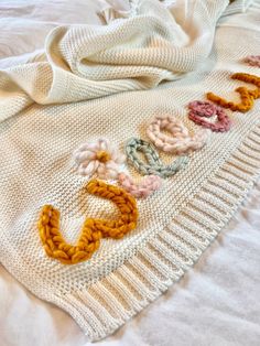 a knitted blanket with the word love spelled out on it