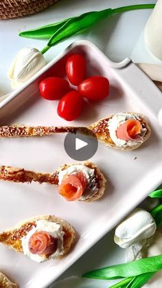 an appetizer plate with tomatoes, scallops and other food items on it