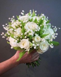 a person holding a bouquet of white flowers