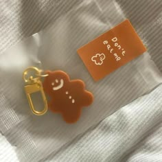 an orange and white teddy bear shaped keychain with a tag attached to it