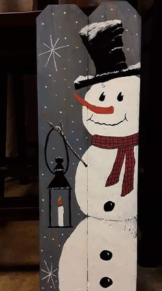 a painted snowman with a lantern and hat