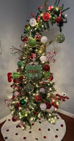 a christmas tree with ornaments and decorations on the top is decorated in red, white and green