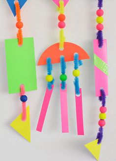 colorful art project made with construction paper and colored stickers on white background, including arrows