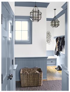 a hallway with blue walls and wooden flooring next to a basket filled with clothes