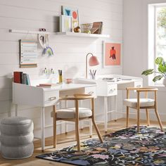 a white desk with two chairs and a rug on the floor in front of it