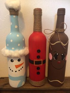 three wine bottles decorated to look like snowmen